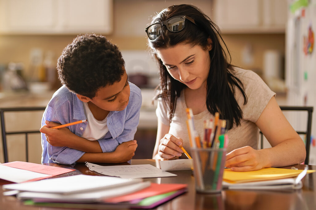 Giovane studente fa i compiti a casa con mamma